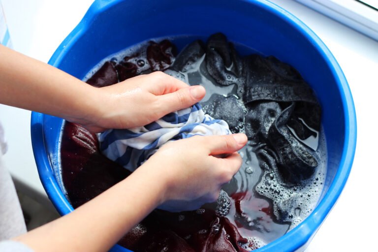a woman washes clothes with her hands in soapy water. hand wash clothes.